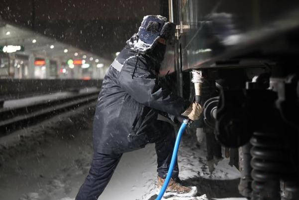 เจ้าหน้าที่รถไฟจีนยืนหยัดทำงานกลางหิมะตกหนัก