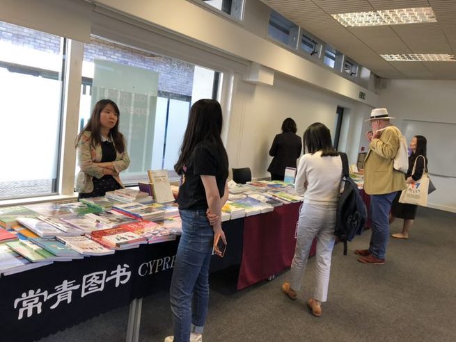 图片默认标题_fororder_高校国际汉语教学大会间隙与会者在教学书籍展示现场观摩选购图书（摄影梁弢）