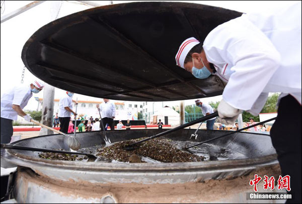 เปิดเทศกาลอาหารเมืองจิ่วเฉวียน พ่อครัว 7 คนช่วยกันปรุงเนื้อแพะในกระทะยักษ์
