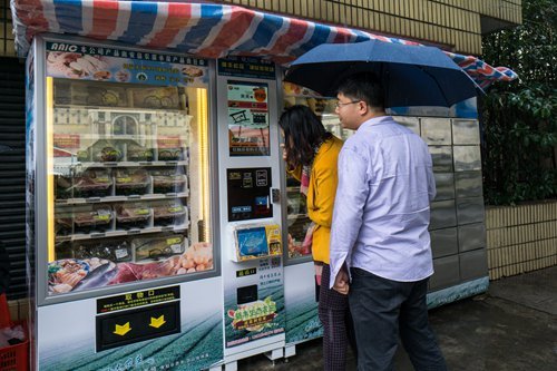 Residents is checking an intelligent market vending machine. [Photos: from Global Times]