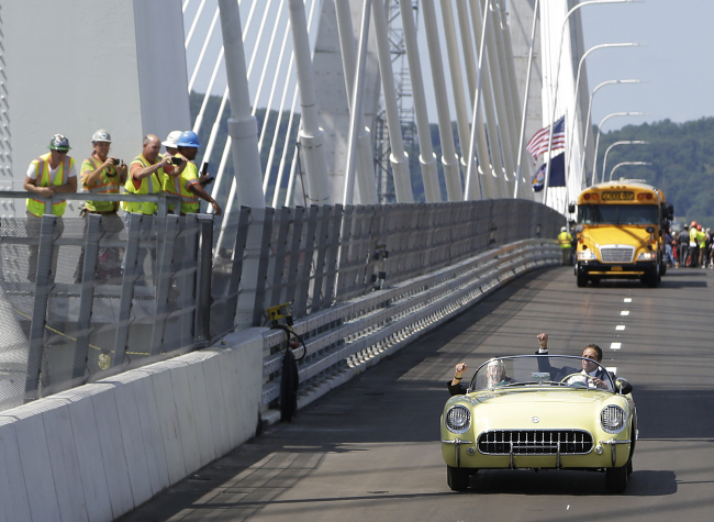 New York Gov. Andrew Cuomo, right, and Armando "Chick" Galella, second from right, wave to construction workers a they cross a span of the Tappan Zee Bridge replacement, called the Gov. Mario M. Cuomo Bridge, near Tarrytown, N.Y., Thursday, Aug. 24, 2017. [Photo: AP]