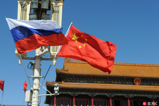 Chinese and Russian national flags flutter on a lamppost in front of Tiananmen Rostrum in Beijing. [File Photo: IC]