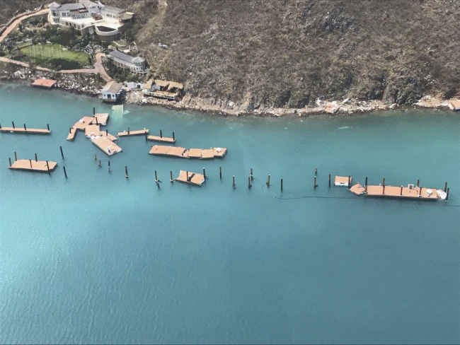 This photo provided on Friday, Sept. 8, 2017, shows the docks damaged by Hurricane Irma at Virgin Gorda's Yacht Club Costa Smeralda in the British Virgin Islands. Irma scraped Cuba's northern coast Friday on a course toward Florida, leaving in its wake a ravaged string of Caribbean resort islands strewn with splintered lumber, corrugated metal and broken concrete. [Photo: AP/Caribbean Buzz Helicopters]