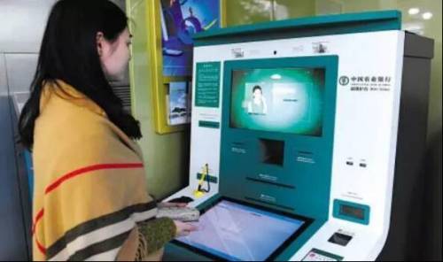 A woman stands in front of an Agricultural Bank ATM machine to have her face scanned. [Photo: hexun.com]