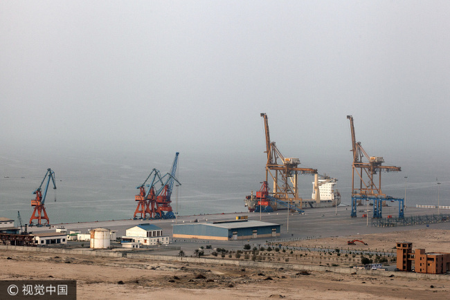 A cargo ship sits berthed next to a crane at Gwadar Port in Gwadar, Balochistan, Pakistan, on Tuesday, Aug. 2, 2016. [Photo: vcg.com]