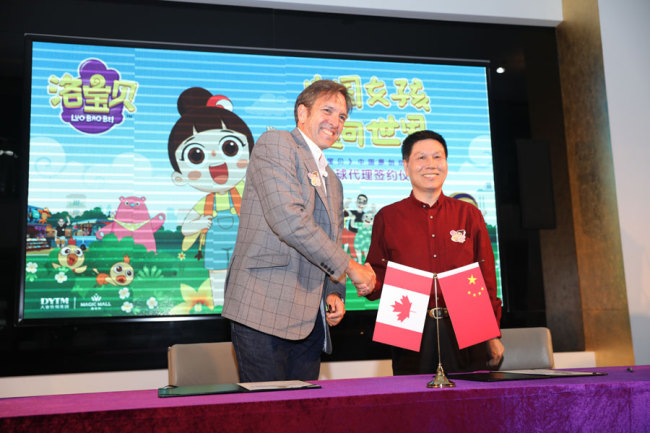DYTM CEO Su Zhong (right) and 9 Story Executive Chairman Neil Court shake hands during the signing ceremony for the international distribution of Chinese animated series Luo Bao Bei. [Photo: China Plus]