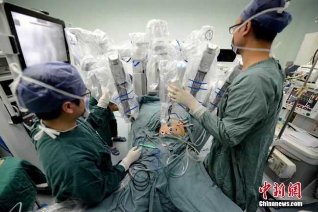 A robot is operating a patient at the Fujian Medical University Union Hospital. [Photo: Chinanews.com]