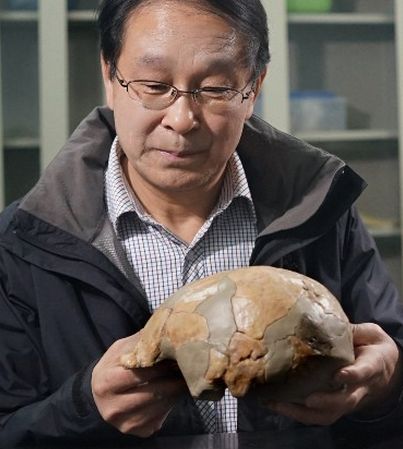 Chinese archaeologist Li Zhanyang holds a cranial fossil of the Xuchang Human. [File photo: youth.cn]