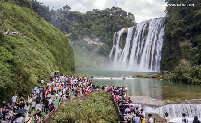 Tourists visit the Huangguoshu Waterfall in Anshun City, southwest China's Guizhou Province, Oct. 2, 2017. China witnessed more than 710 million tourist trips during the eight-day National Day and Mid-Autumn holidays, ringing up to over 580 billion yuan (88.68 billion U.S. dollars) in tourism income, according to the National Tourism Administration. [Photo: Xinhua/Chen Xi]