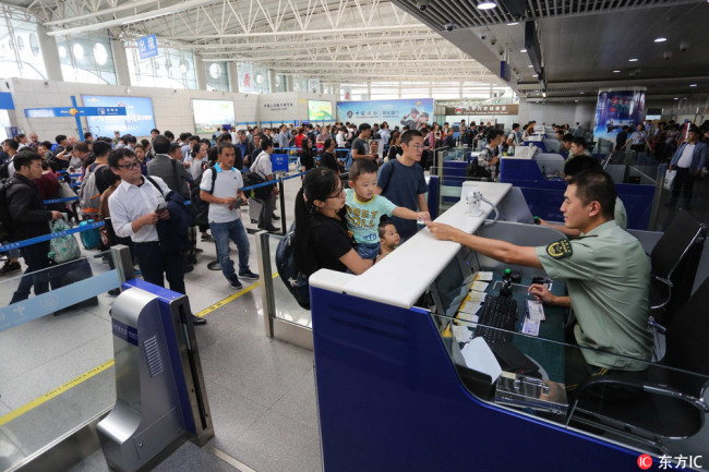 A family traveling overseas go through customs clearance at a border inspection post at an airport. [File photo: IC]