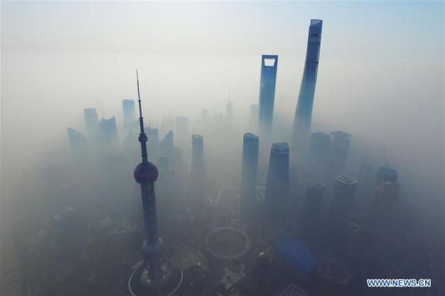 Aerial photo taken on April 14, 2016 shows fog-shrouded buildings in Shanghai, east China. [Photo: Xinhua/Shen Chunchen]
