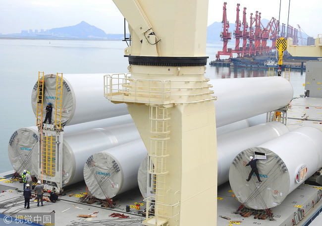 Chinese-made wind towers hoisting to a ship at Lianyungang Port, Jiangsu Province on October 27, 2017. [Photo: VCG]