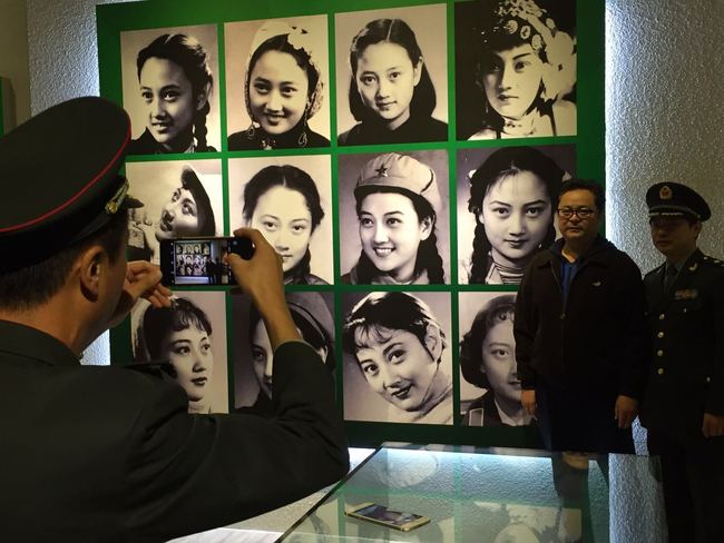 Visitors at an exhibition reviewing 83-year old Chinese actress Wang Xiaotang's major achievements in Beijing take a picture in front of a photo gallery on Saturday, October 28, 2017. [Photo: China Plus]