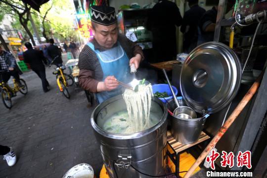Lan Jianbo cooking hand-pulled noodles for customers at his restaurant in Xi’an, northwest China’s Shaanxi Province, on November 2, 2017. [Photo: Chinanews.com]
