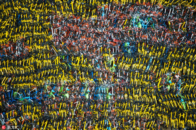 A bird's eye view of 10,000 shared bikes, seized in Shenzhen, south China's Guangdong Province, on September 28, 2017. They were taken off the streets for being parked haphazardly. The Urban management authorities are holding them in an open space until the bike companies come to collect them. [File photo: IC]