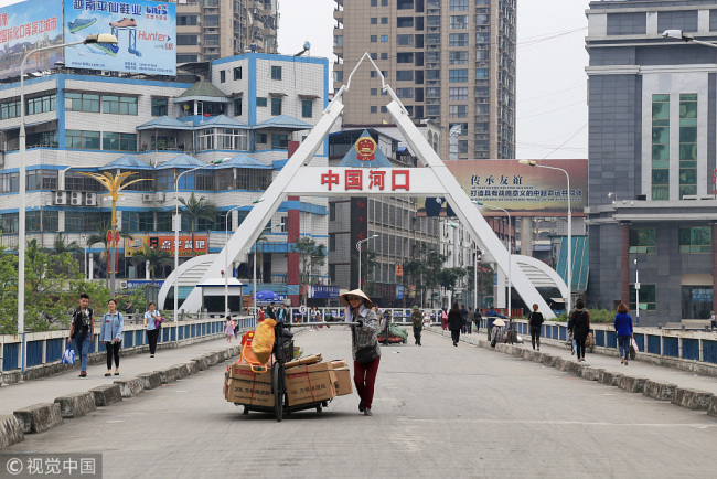 A Vietnamese walks across the Hekou Port, southwest China’s Yunnan Province, with a cart full of goods. Hekou is a busy port where many Vietnamese residents come for trade. [Photo: VCG]