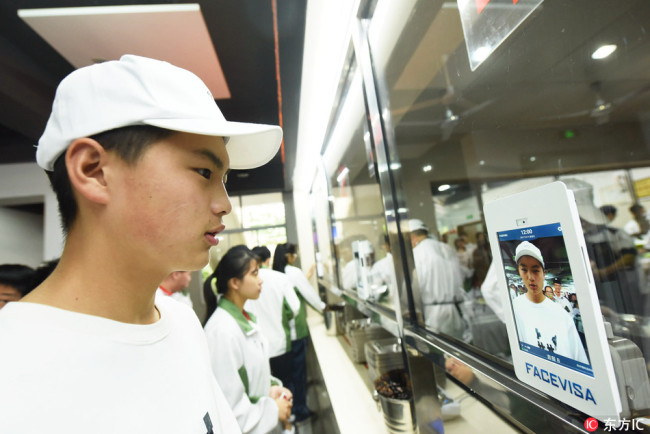 A student looks at the camera using facial recognition to pay for a meal. [Photo: IC]