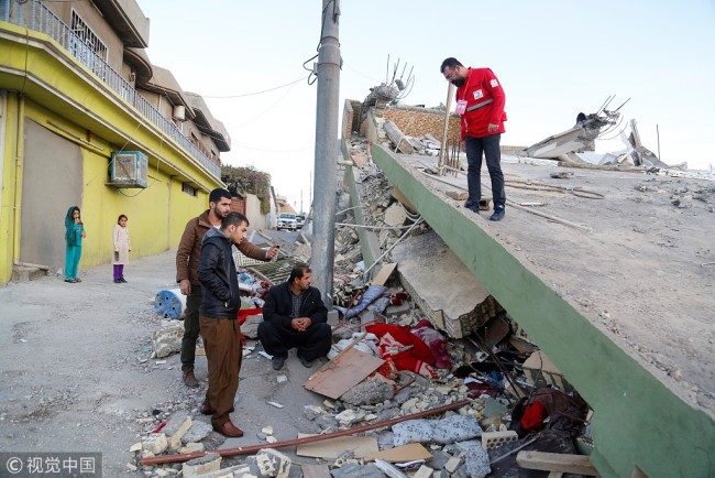 Members of the Turkish Red Crescent, who reached the region as a first response, observe a collapsed building in Derbendihan district of Sulaymaniyah, Iraq on November 13, 2017.[Photo: VCG]