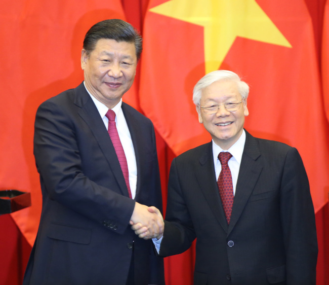 Chinese President Xi Jinping, also general secretary of the Communist Party of China Central Committee, and Nguyen Phu Trong, general secretary of the Communist Party of Vietnam Central Committee, witness the signing of a memorandum of understanding on joint implementation of the Belt and Road Initiative and Vietnam's "Two Corridors and One Economic Circle" plan, as well as a series of cooperation documents in such areas as industrial capacity, energy, cross-border economic cooperation zone, e-commerce, human resources, economy and trade, finance, culture, health, media, social science, and border defense, after their talks in Hanoi, Vietnam, Nov. 12, 2017. [Photo: Xinhua/Yao Dawei]
