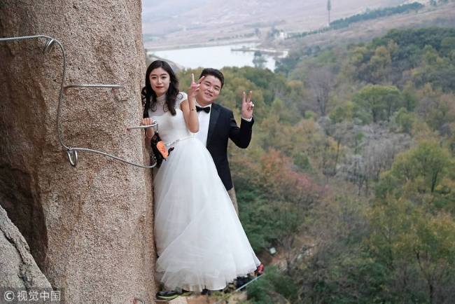 惊心动魄的婚纱照！Newlyweds dangled from a cliff for wedding photos