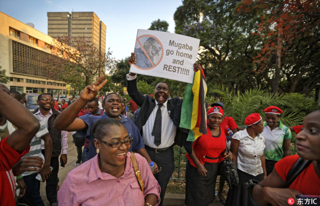 Zimbabweans celebrate outside the parliament building immediately after hearing the news that President Robert Mugabe had resigned, in downtown Harare, Zimbabwe Tuesday, Nov. 21, 2017. [Photo: IC]
