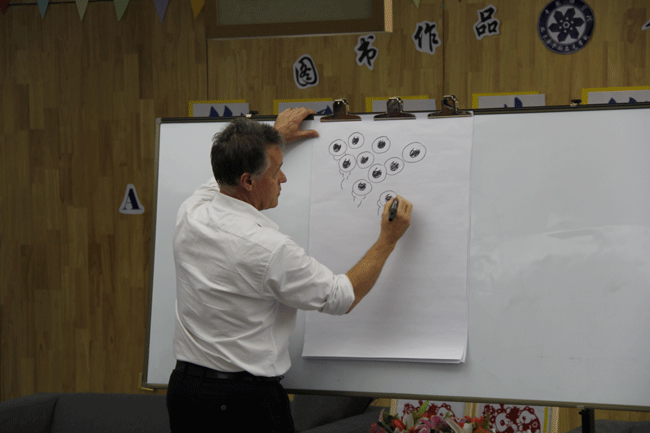 Graeme Base draws for local students in Beijing during his China tour. [Photo:Courtesy of the Australian Embassy to China]