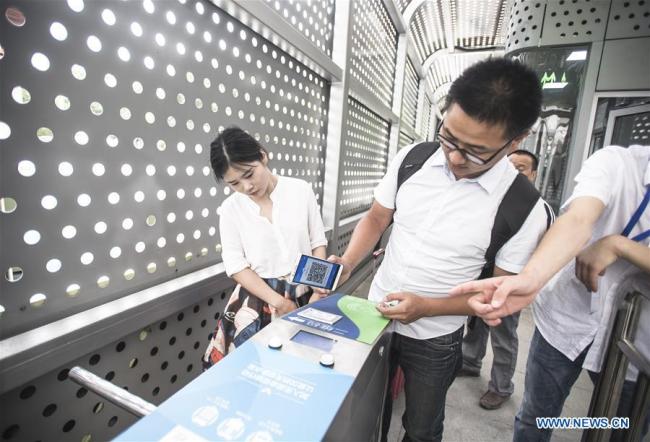 A passenger uses his cellphone to pay for the ticket at Wuchang Station of the Bus Rapid Transport (BRT) in Wuhan, capital of central China's Hubei Province, June 14, 2017. 