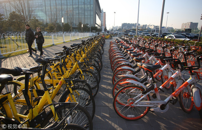 Photo taken on November 20, 2017 shows shared bikes from China's bike sharing companies Mobike and ofo parked along Datun Road in Beijing. [Photo: VCG]