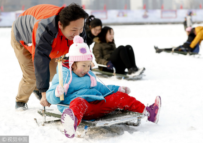 Parents and their children enjoy ice-based recreational activities at Yuyuantan Park in Beijing on December 28, 2017. [Photo: VCG]
