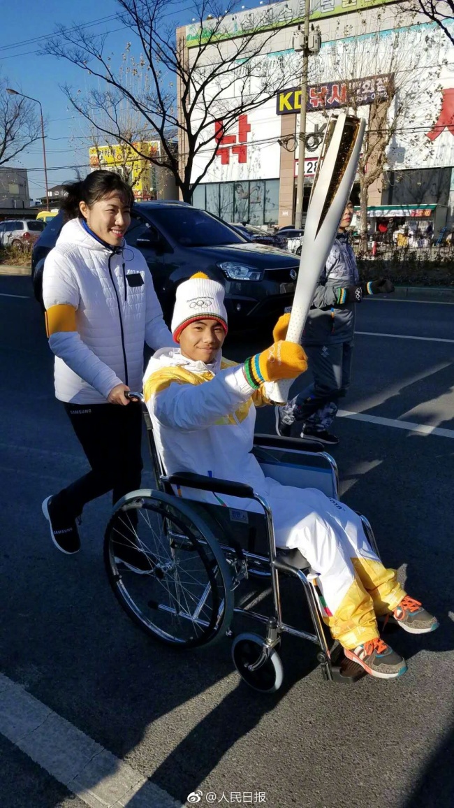 Yan Yuhong carrys the Olympic torch for Pyeongchang Olympic and Paralympic Games in South Korea, January 1, 2018. [Photo: weibo.com]