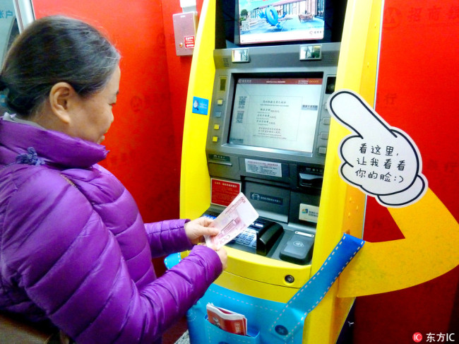 A woman is withdrawing money from a facial recognition able ATM machine in Nanjing, Jiangsu Province on Nov 17, 2017. [Photo: IC]