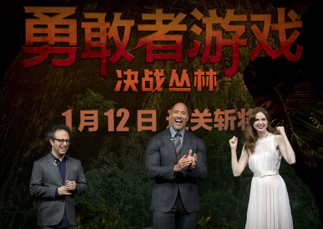 From left, American director Jake Kasdan, American actor Dwayne Johnson, and British actress Karen Gillan laugh during a press conference for the movie 'Jumanji: Welcome to the Jungle' in Beijing, Thursday, Jan. 4, 2018. The hit movie opens in China on Jan. 12. [Photo: AP/Mark Schiefelbein]