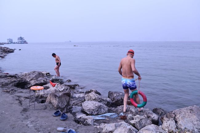Two swimming enthusiasts prepare for winter swimming in Wuhan, capital city of Hubei Province, on December 27, 2017. [Photo: China Plus/Huang Yue]
