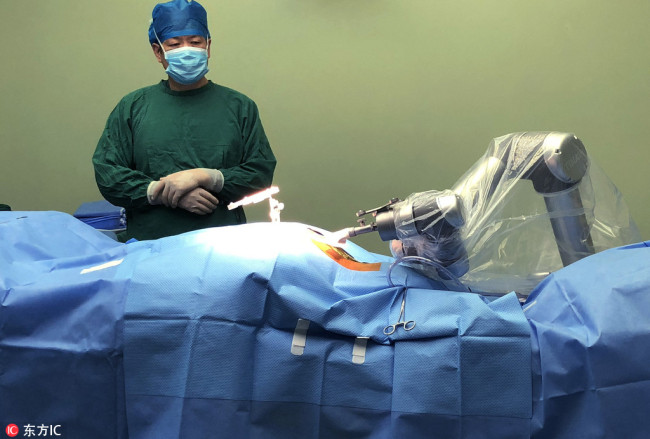 A doctor watches as Tianji performs an orthopedic surgery on a 43-year-old patient at a hospital in Hefei, January 3, 2018.[Photo: IC]