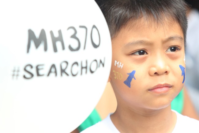 A Malaysian child holds a balloon and gets his face painted for the victims of the missing MH370 airplane in Kuala Lumpur, Malaysia on March 04, 2017, in commemoration of Malaysia Airlines Flight MH370. [File photo: IC/Alexandra Radu]