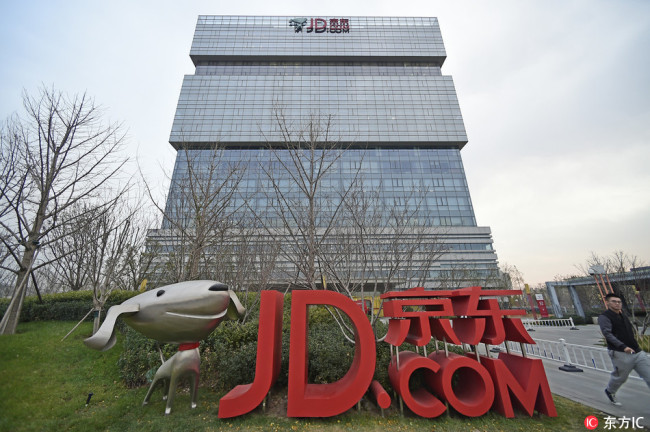 A pedestrian walks past the headquarters of Chinese online retailer JD.com in Beijing, China, October 16, 2017.[File Photo: IC]