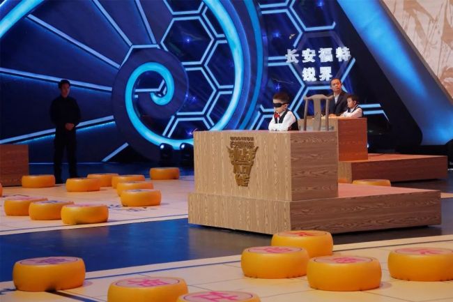 Yang Shengxuan, a 6-year-old boy from Henan Province, plays a simultaneous game of Xiangqi blindfolded against two other players in a CCTV program called "Impossible Challenge," also known as "Beyond the Edge." [Photo: CCTV]