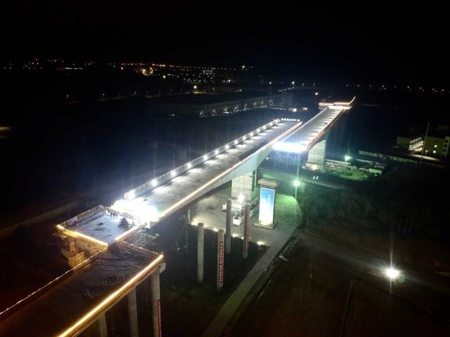 The rotation construction of two sections of a highway bridge over high-speed railway is completed in Guangzhou on Friday, January 26, 2018. [Photo: China Plus]