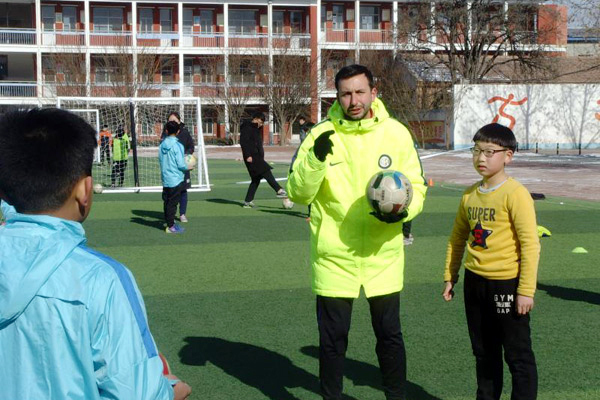 A coach from Football Club Internazionale Milano teaches soccer at Xiongxian No. 1 Primary School in Hebei Province, Jan. 29, 2018. [Photo provided to China Daily]