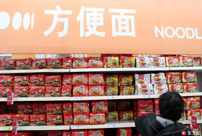 A citizen selects instant noodle at a supermarket in in Nanjing city, east China´s Jiangsu province, on January 20, 2018. [Photo: IC]