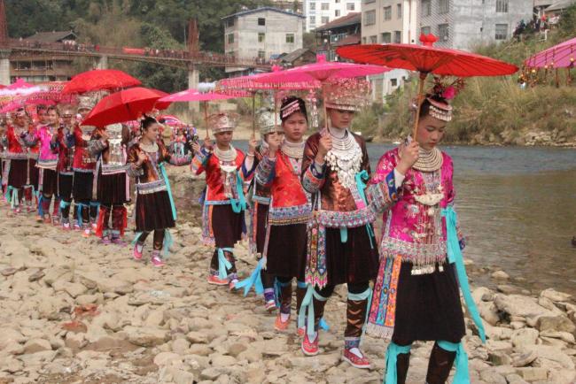 Teenage girls filing down the riverbed in the Danian village in Sanjiang County, Guangxi Zhuang Autonomous Region. Children also partake in the event together with their parents. [Photo: Provided to China Plus/Lu Zhiyan]