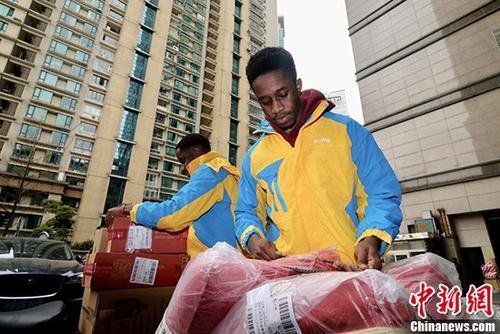 Twin brothers Bai Tong and Wei Mo are distributing parcels at a delivery station for Suning. [Photo: Chinanews.com]