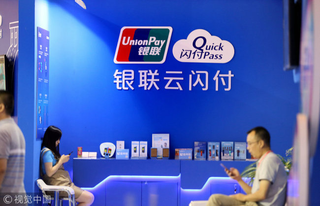 Two visitor are seen at the stand of China UnionPay during a financial expo in Beijing. [File Photo: VCG]