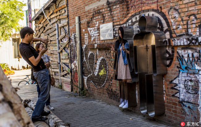 Visitors take photos at Beijing's 798 Art Zone, which was once an industrial area. [File Photo: IC]