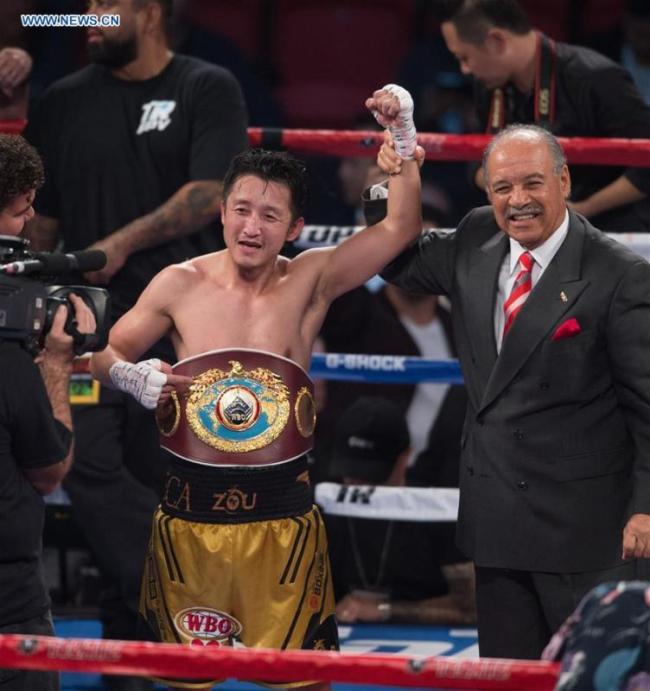 Zou Shiming (L) of China celebrates after defeating Prasitak Phaprom of Thailand in a WBO flyweight title boxing match in Las Vegas, the United States, Nov. 5, 2016. [Photo: Xinhua]