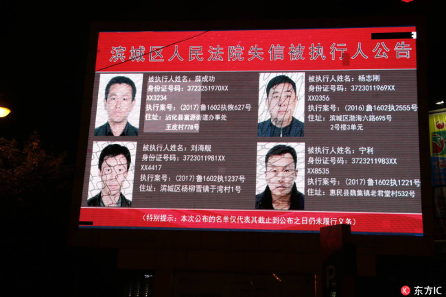 The People's Court in Binzhou, Shandong Province publishes information of some deadbeat debtors on a big screen at the city's busiest street on September 13, 2017. [Photo: IC]