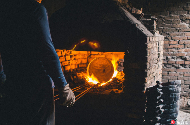 It takes 12 different steps to make a Zhangqiu iron wok. [Photo: IC]