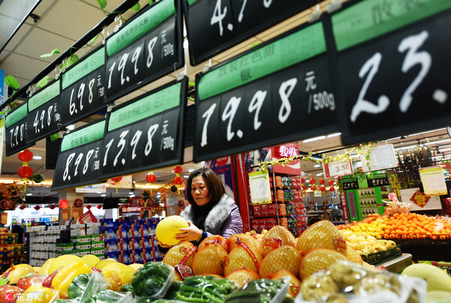 A customer shops for fruit at a supermarket in Hangzhou, Zhejiang Province, February 9, 2018. [Photo: IC]