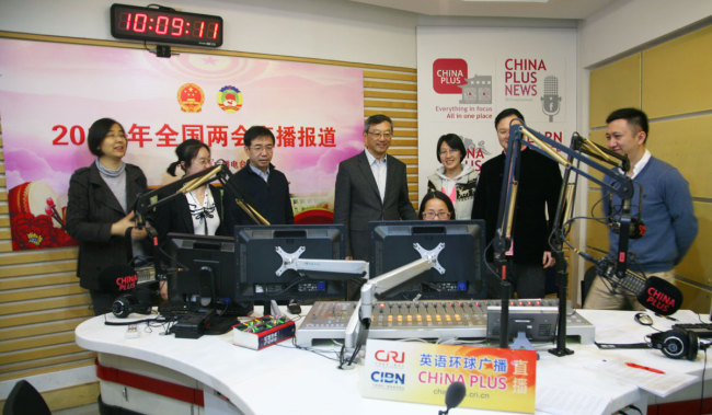 Wang Lian(4th, left), chief engineer of China Radio International(CRI), inspects China Plus's live broadcast room in Beijing, on March 4, 2018. [Photo: China Plus]