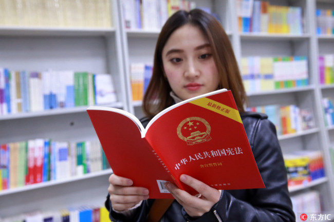 A reader reads China's amended Constitution in Wangfujing Bookstore in Beijing on March 13, 2018. [Photo: IC]